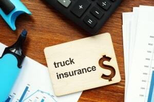 A Card with Truck Insurance Text on Table with Calculator and Marker