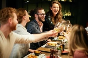 best friends sitting in restaurant for dinner and making a toast with white wine