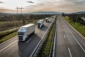 caravan or convoy of trucks in line on a country highway