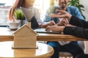 closeup house model over the sale representative offer the house price list and condition for house purchase or rental on the working space table in new house