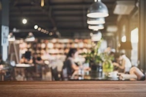 empty wooden table space platform and blurry defocused restaurant interior