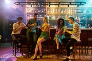 full length shot of young men drinking cocktail at the bar counter and flirting with women they just met