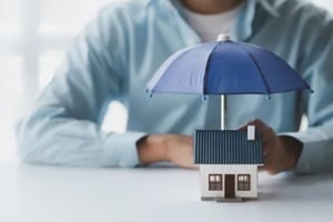 individuals holding small umbrellas and model homes