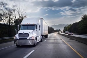 white 18 wheeler truck on highway at night