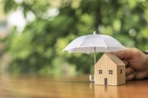 White Umbrella Protecting A House Representing Home Insurance Concept